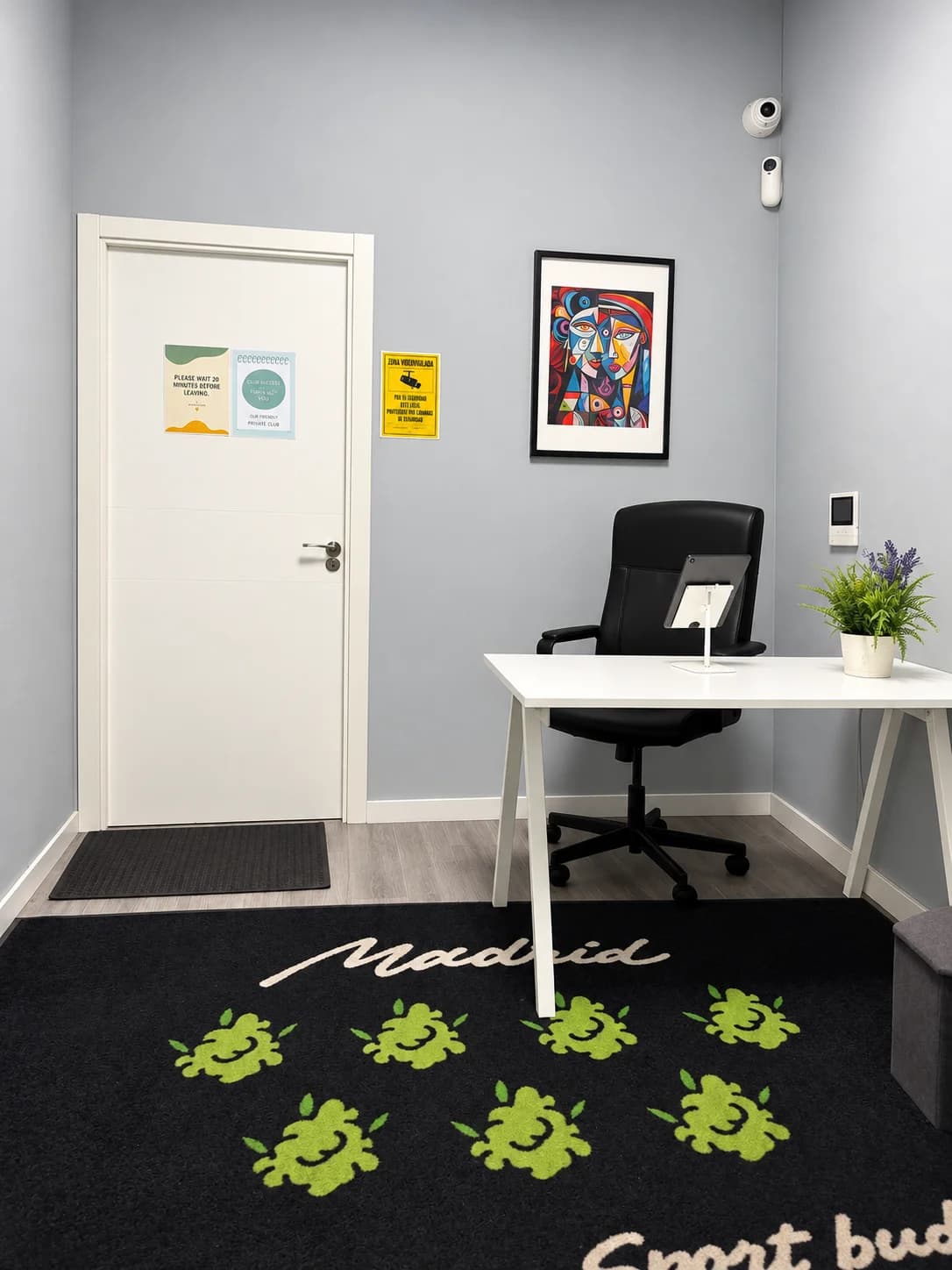 Weed Club Malasaña reception with a white desk, black chair and wall decorations